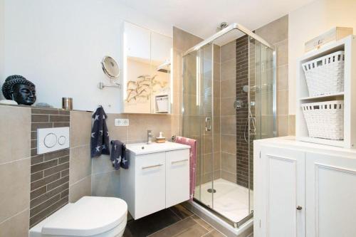 a bathroom with a shower and a toilet and a sink at Appartement-Leuchtturmblick in Hörnum