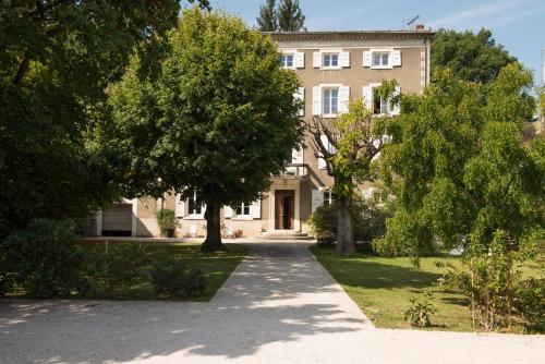 un grand bâtiment avec des arbres devant lui dans l'établissement La Saudade, à Saint-Péray