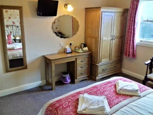 una camera con letto, cassettiera e specchio di Crow Park Hotel a Keswick