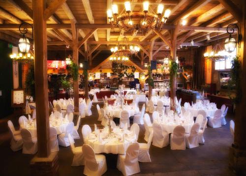 um quarto amplo com mesas e cadeiras brancas e um lustre em Hotel Restaurant Zur Post Lohfelden em Kassel