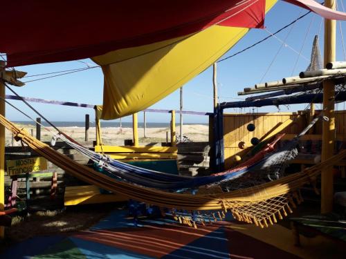 eine Gruppe Hängematten auf einem Boot am Strand in der Unterkunft Hostel Francisca in La Pedrera