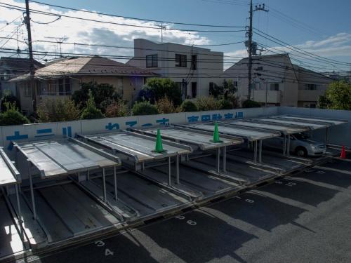 un gruppo di rimorchi metallici parcheggiati in un parcheggio di Hotel Route-Inn Tokyo Asagaya a Tokyo