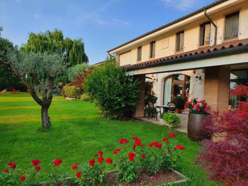 una casa con un patio con flores rojas en Agriturismo il Cascinale, en Treviso