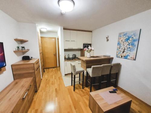 una cucina e un soggiorno con tavolo e sedie di Apartment U 154 - Aparthotel Vučko a Jahorina