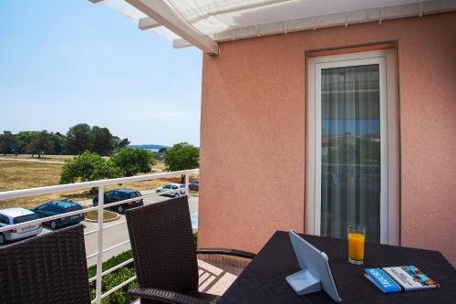 een tafel op een balkon met uitzicht op een parkeerplaats bij Apartments Villa Brioni II in Fažana