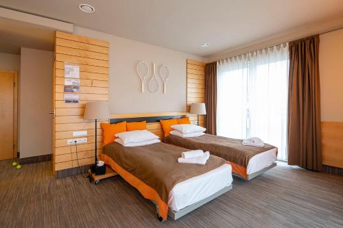 A bed or beds in a room at Hotel Restauracja Tenis Kortowo