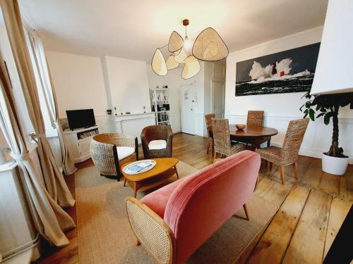 een woonkamer met een bank, stoelen en een tafel bij Les Sablons - Très Bel Appartement , Lumineux in Saint-Malo