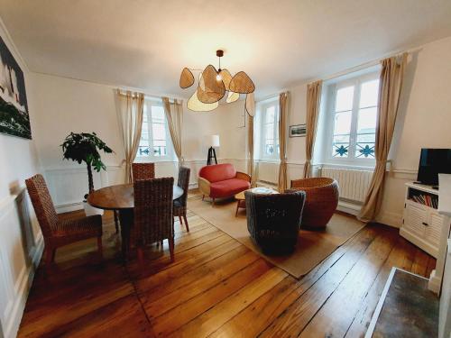 een woonkamer met een tafel en een rode stoel bij Les Sablons - Très Bel Appartement , Lumineux in Saint-Malo