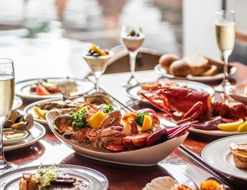 a table with plates of food and glasses of champagne at The Sukhothai Bangkok in Bangkok