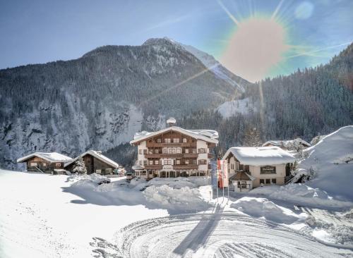 a ski lodge in the snow in front of a mountain at Hotel Dornauhof in Finkenberg