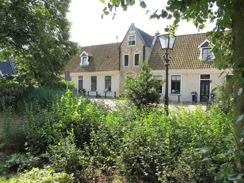 uma casa com uma luz de rua em frente em De Thuiskamer in Grou als B&B of Vakantiehuis em Grou