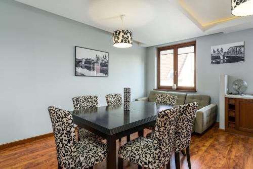 una sala da pranzo con tavolo e sedie di Sleepway Apartments- Szyperska a Poznań