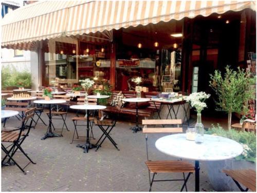 een groep tafels en stoelen buiten een restaurant bij Bookstor Hotel in Den Haag