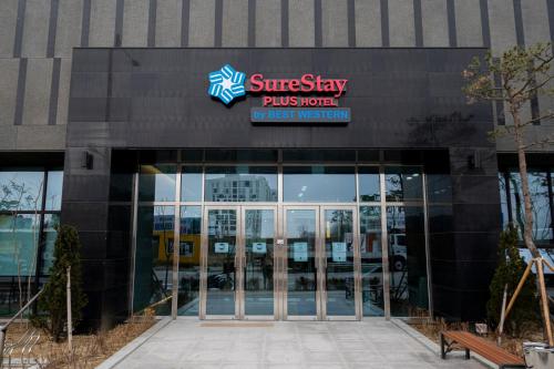 a building with the entrance to a suns stay plus hotel at SureStay Plus Hotel by Best Western Asan in Asan