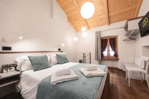 een slaapkamer met een groot bed en handdoeken bij Aosta Centre Apartments - Martinet 17 in Aosta