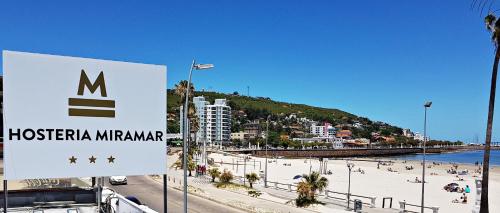 un cartello su una spiaggia con persone sulla spiaggia di Hostería Miramar a Piriápolis