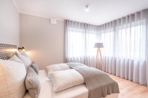 een witte slaapkamer met een bed en een raam bij The Woodmans Airport Boardinghouse in Düsseldorf