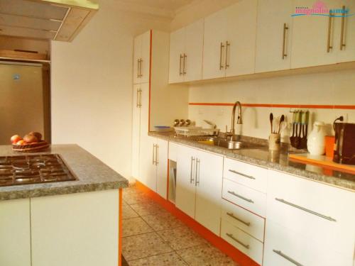 a kitchen with white cabinets and a counter top at Hostal Magnolio in Viña del Mar