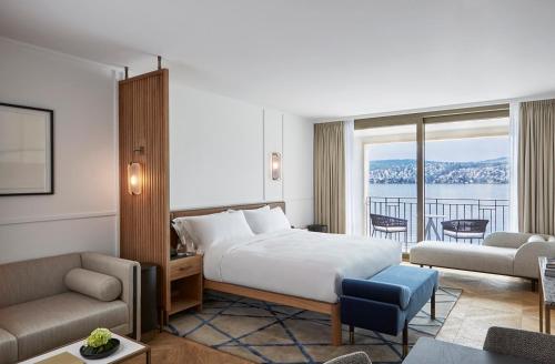 Habitación de hotel con cama y sala de estar. en Alex Lake Zürich - Lifestyle hotel and suites, en Thalwil