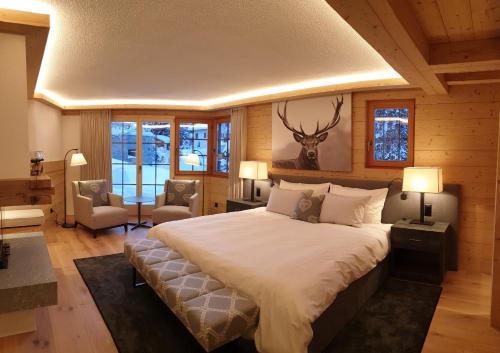 een slaapkamer met een groot bed met een hertenkop aan de muur bij Chalet Chesa Surlej, Davos in Davos