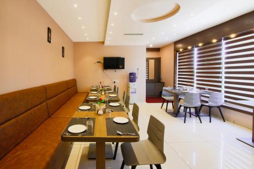 a dining room with long tables and chairs at Aloka Stay Inn in Vellore