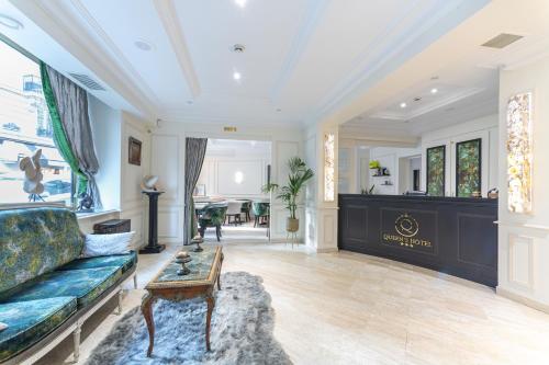 a living room with a couch and a table at Queens Boutique Hotel in Paris