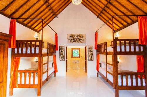 um quarto com 2 beliches e um corredor em Camar Cottage & Hostel em Nusa Penida