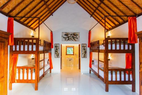 um quarto com 2 beliches e um corredor em Camar Cottage & Hostel em Nusa Penida