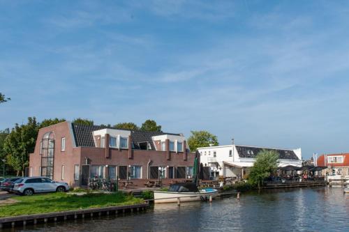 una casa en el agua junto a un río en De Watersport Heeg, en Heeg