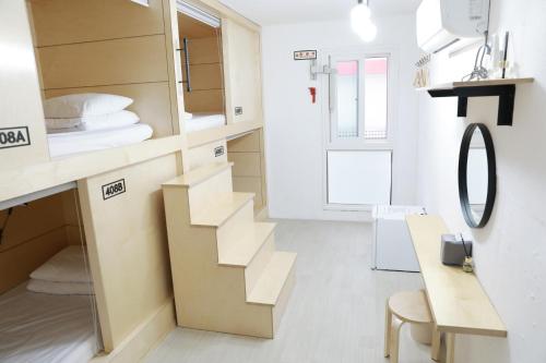 een kleine kamer met een trap en een spiegel bij Minihotel Poongdaengi in Gyeongju