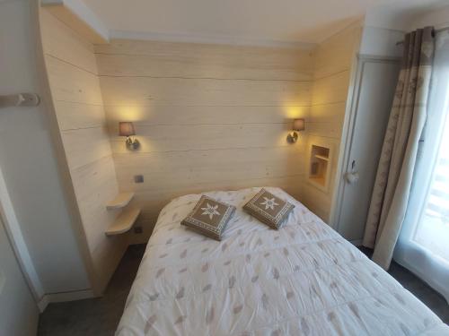 a bedroom with a bed with two pillows on it at Chalet Monte-Pente in Megève