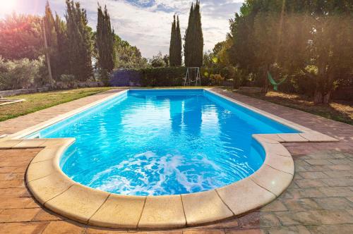 a swimming pool in a yard with a stone patio at Appartamento Villa Matone in Grottaferrata