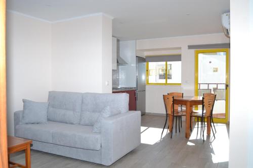 uma sala de estar com um sofá e uma mesa em Rocha Apartment 1016 em Portimão