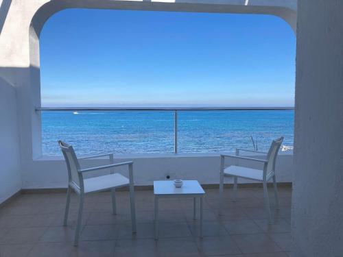 a table and chairs with a view of the ocean at Dar Corniche La Marsa (Adults Only) in La Marsa