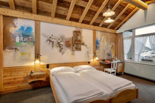 a bedroom with a large white bed in a room at Hotel Antika in Zermatt