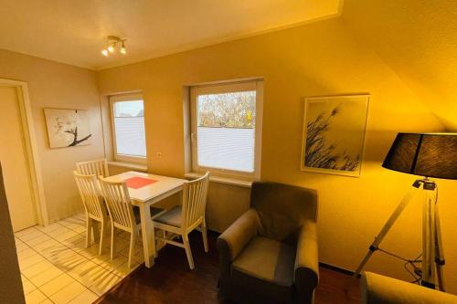 a living room with a table and a chair at Exclusives Apartment im Herzen von Westerland in Westerland (Sylt)