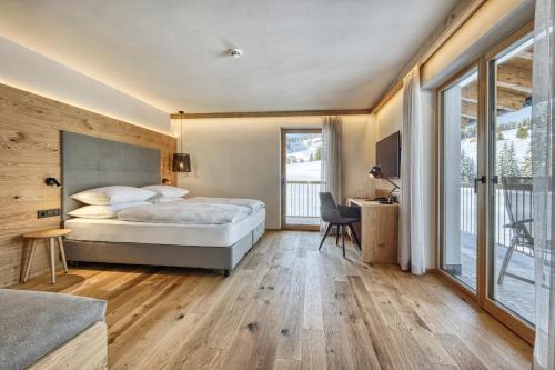 A bed or beds in a room at Brunelle Seiser Alm Lodge