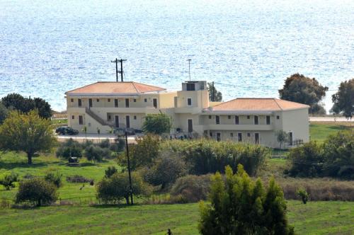 un grand bâtiment blanc en face de l'eau dans l'établissement Finiki Plaza, à Methoni