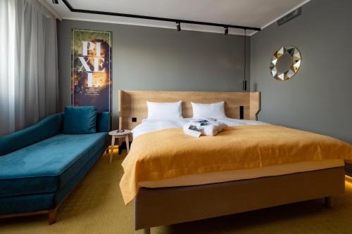 um quarto com uma cama e um sofá azul em elaya hotel stuttgart boeblingen em Böblingen