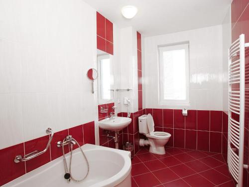 un bagno rosso e bianco con servizi igienici e lavandino di Hotel Trend a Plzeň