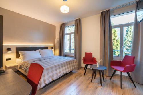 Rúm í herbergi á Hotel Derby Interlaken - Action & Relax Hub