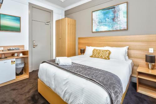 A bed or beds in a room at Meridian Hotel Hurstville