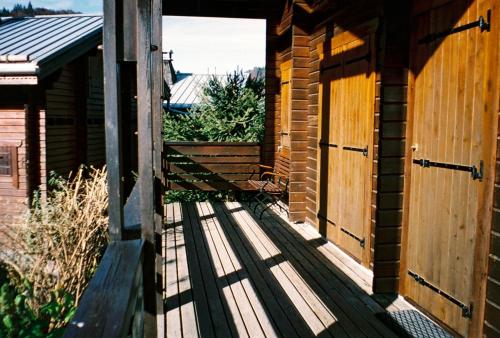 einen Eingang zu einem Gebäude mit einer Holzterrasse in der Unterkunft Chalet cosy a Sixt Fer a Cheval avec vue sur la montagne in Sixt