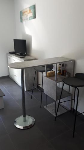 - un bureau avec 2 chaises et un ordinateur dans l'établissement charmant studio dans résidence neuve et calme, à Corte