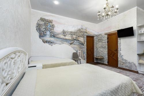 a bedroom with two beds and a mural on the wall at Апартаменти в Старому Місті Sweet House in Kamianets-Podilskyi