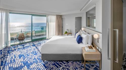 A bed or beds in a room at Crowne Plaza Sydney Coogee Beach, an IHG Hotel