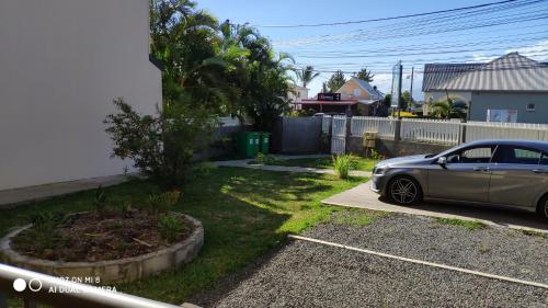 une voiture garée dans une allée à côté d'une maison dans l'établissement LE SHANTI, à Saint-Pierre