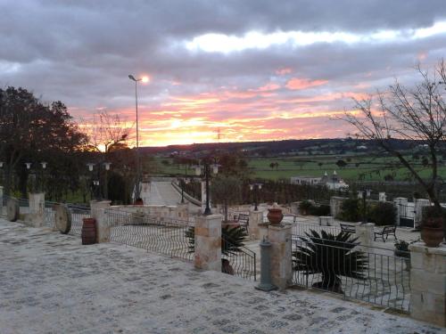 a cemetery with a fence and a sunset in the background at Masseria Torricella in Alberobello