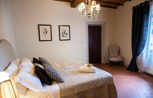 een slaapkamer met een bed en een kroonluchter bij Appartamento I Bacchettoni in Pistoia