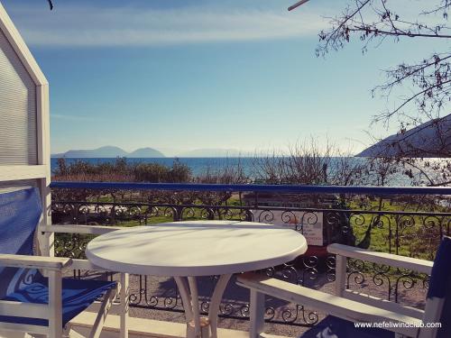 un tavolo su un balcone con vista sull'oceano di Nefeli a Vassiliki